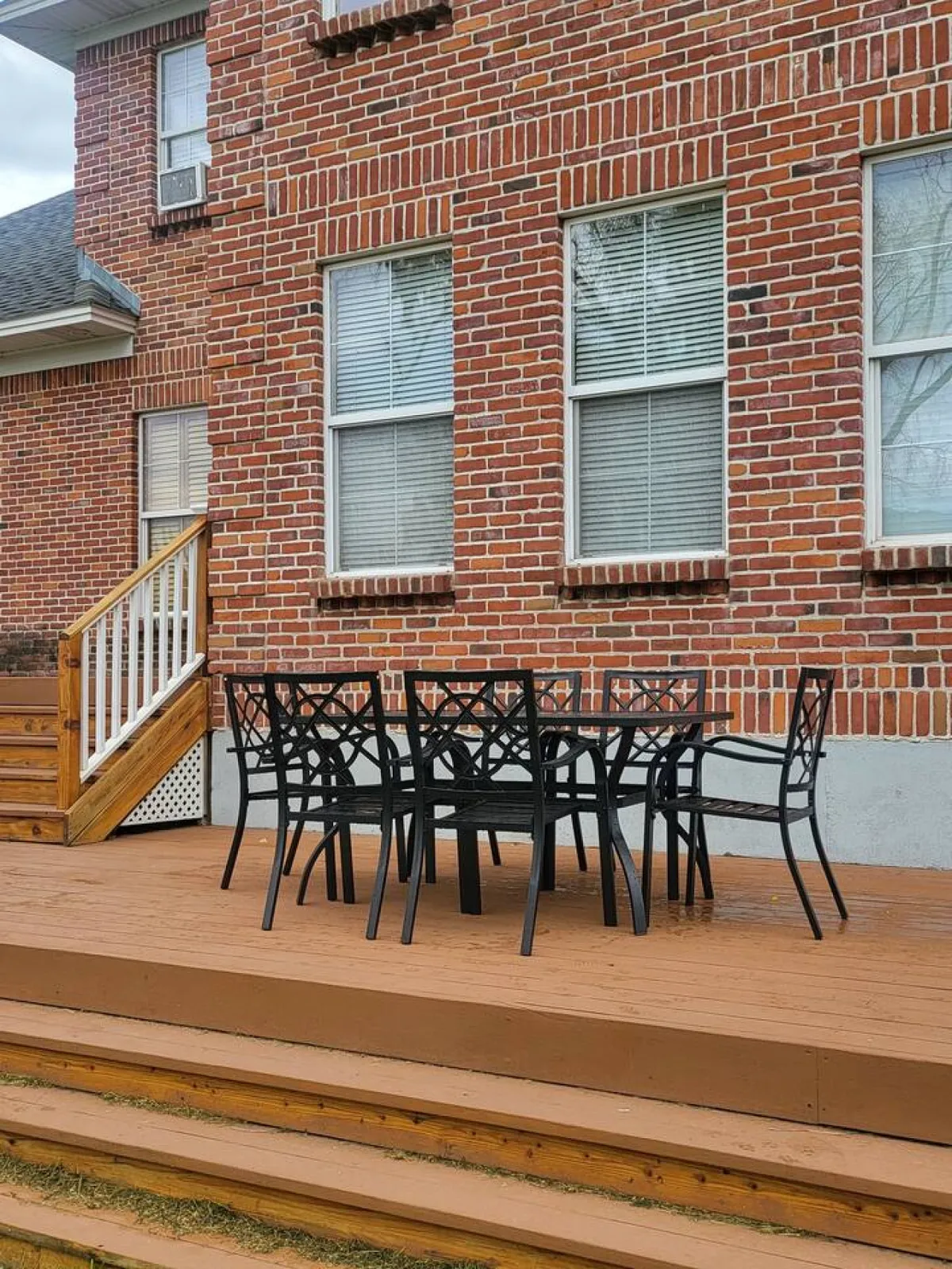 An outdoor dining table and chairs are arranged next to a brick wall, set up for relaxed gatherings. The setup hints at both social and peaceful moments, with room for friends or family to share meals or spend evenings under the stars.